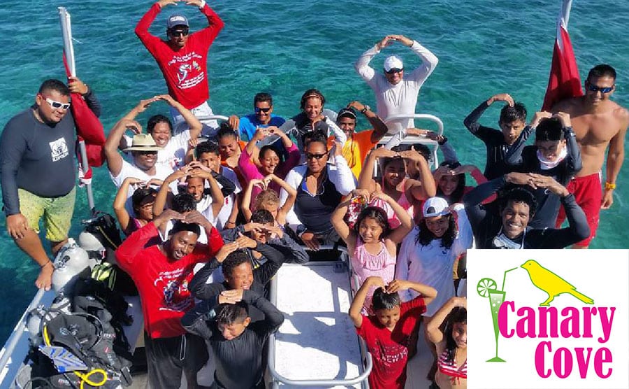 Belize community members gathered on a dive boat